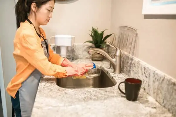 Woman in an apron washing up