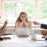 Perplexed,Young,Woman,Looking,At,Coworkers,Pointing,Fingers,At,Her.