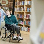Cheerful,Positive,Handsome,Disabled,Student,With,Headphones,On,Neck,Sitting
