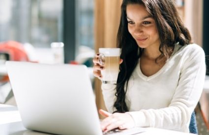 Brunette,Studying,On,Laptop,And,Enjoying,Coffee