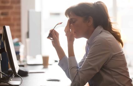 Exhausted,Female,Worker,Sit,At,Office,Desk,Take,Off,Glasses